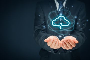 Businessperson holding a glowing cloud computing icon with arrows, symbolizing data exchange and cloud technology.