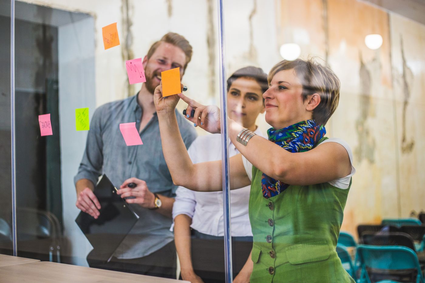 3 people looking at post it notes